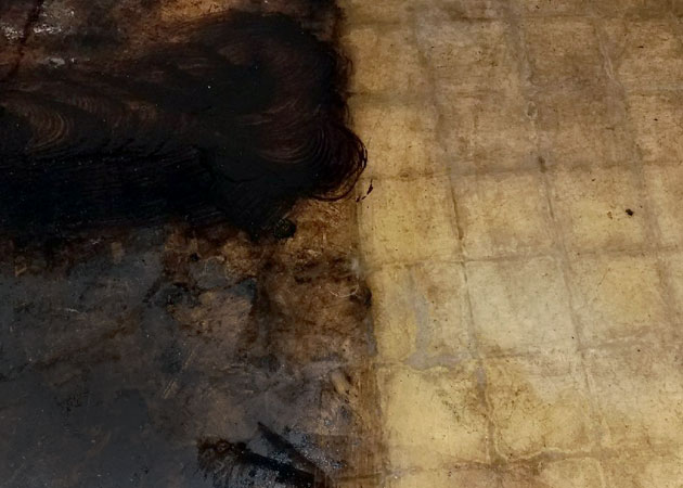 A floor showing asbestos mastic in the process of being removed
