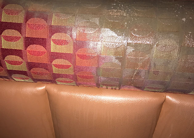 A restaurant booth in the process of being cleaned